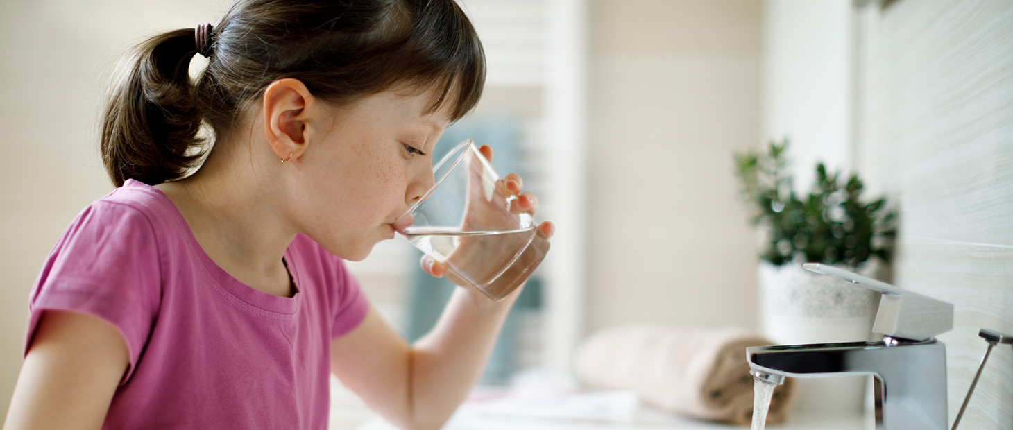 Young girl drinking a glass of water