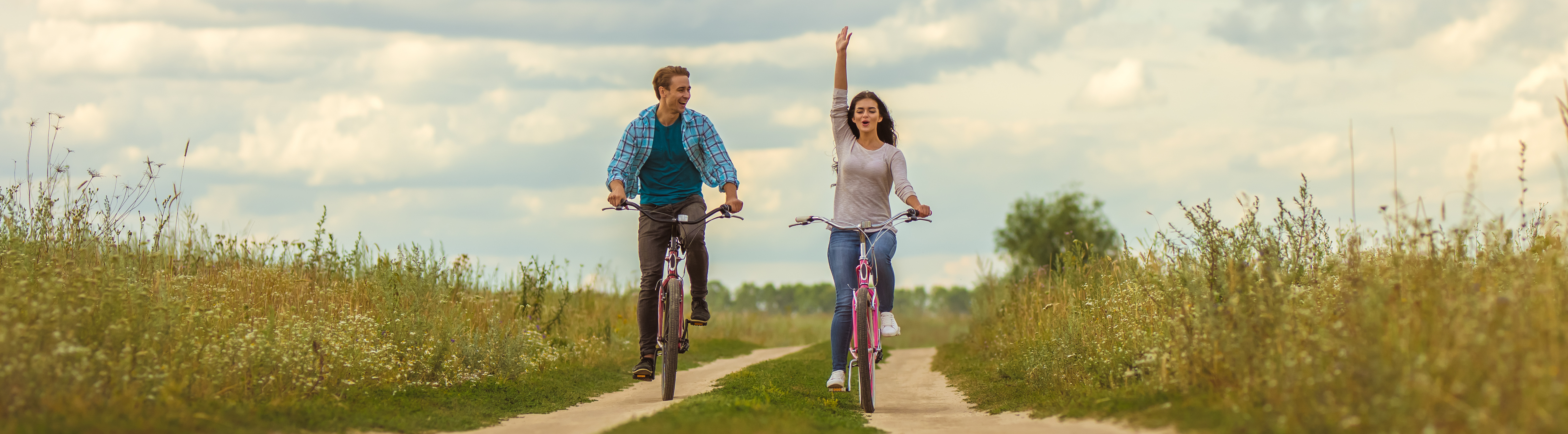 Man and woman riding a bike on a trail
